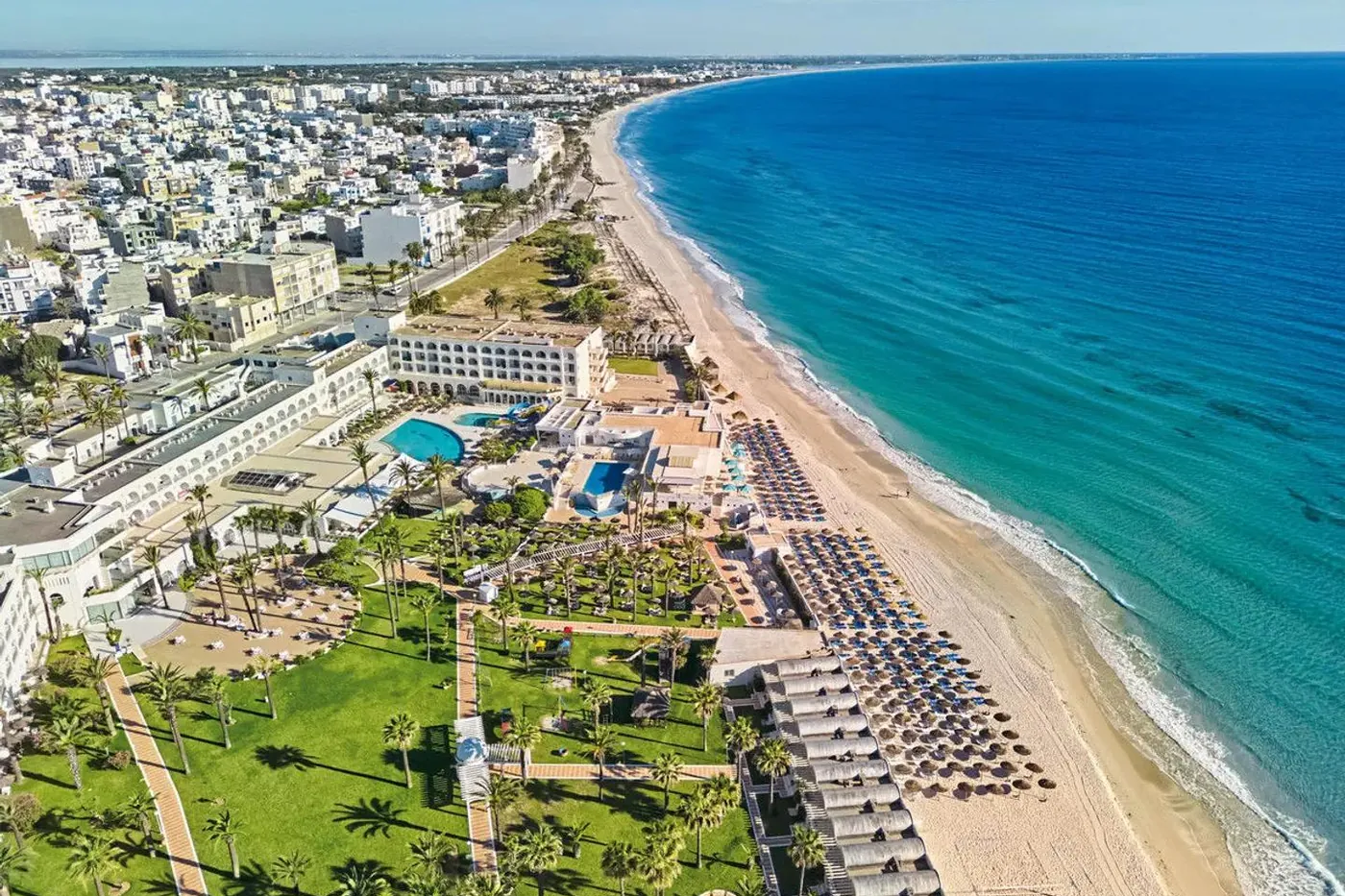 Aerial view of a beachfront resort strip along a Mediterranean bay