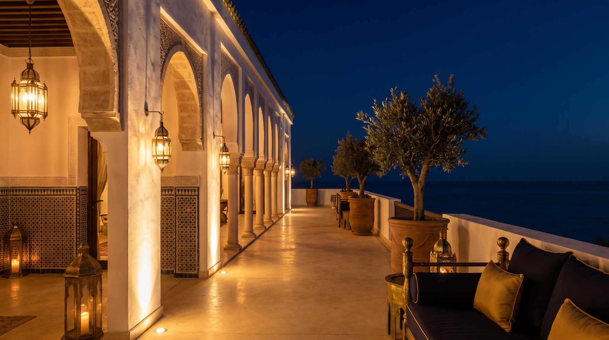 Illuminated colonnade of a North African villa at dusk overlooking the Mediterranean
